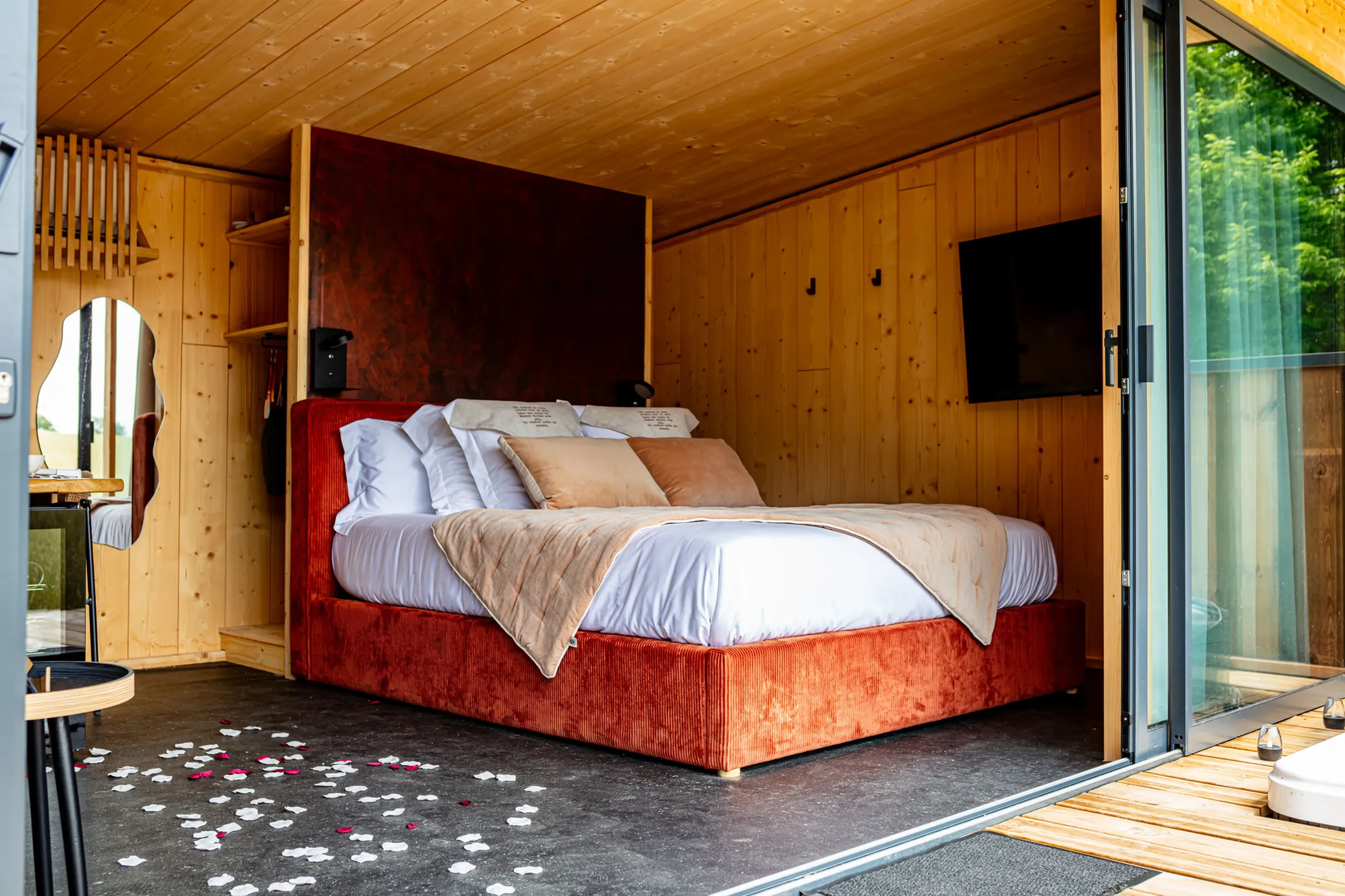 Chambre moderne en bois avec lit et pétales.