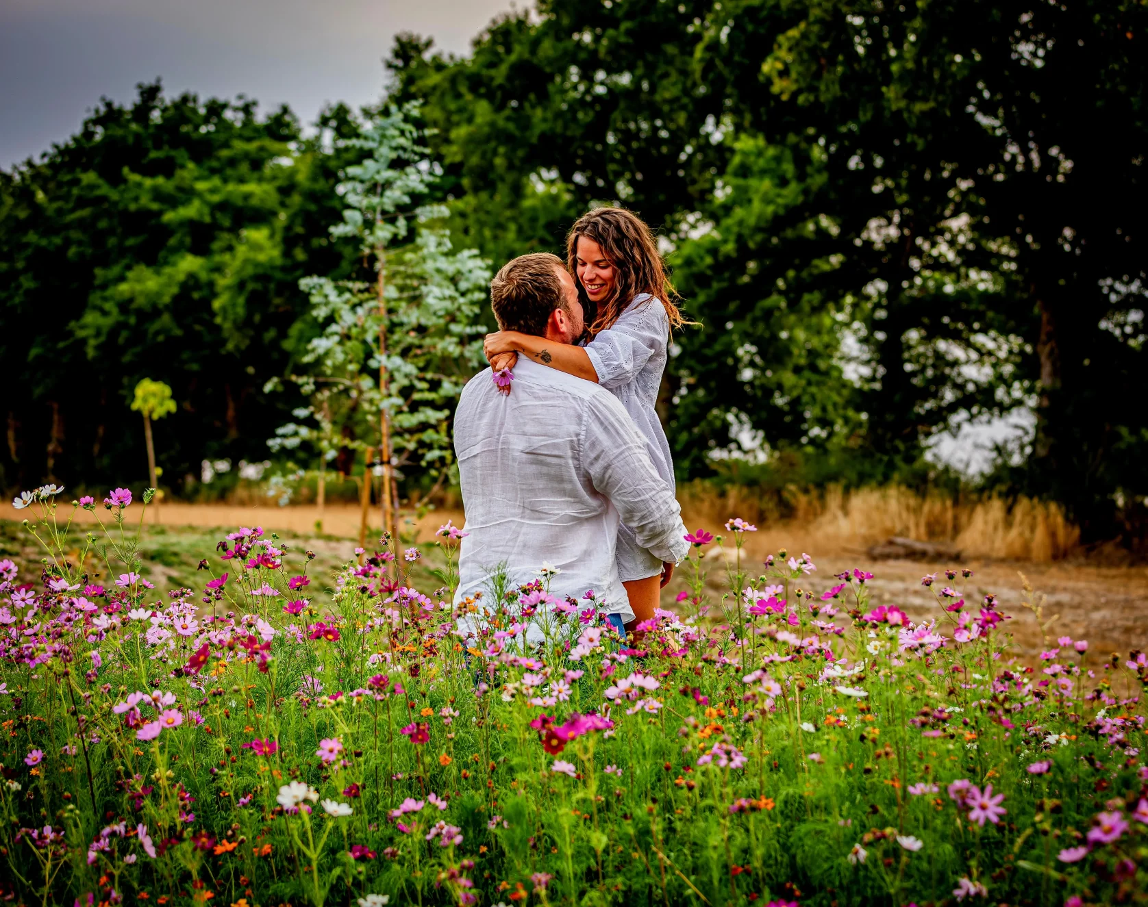 Couple s'enlaçant dans un champ de fleurs sauvages