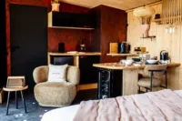 Studio chaleureux avec cuisine et coin salon.