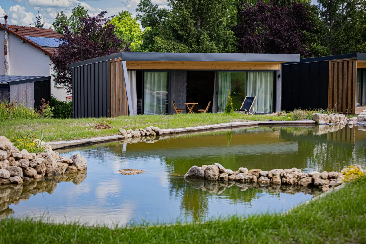 Maison moderne près d'un étang calme.