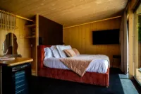 Chambre en bois avec lit et télé murale.