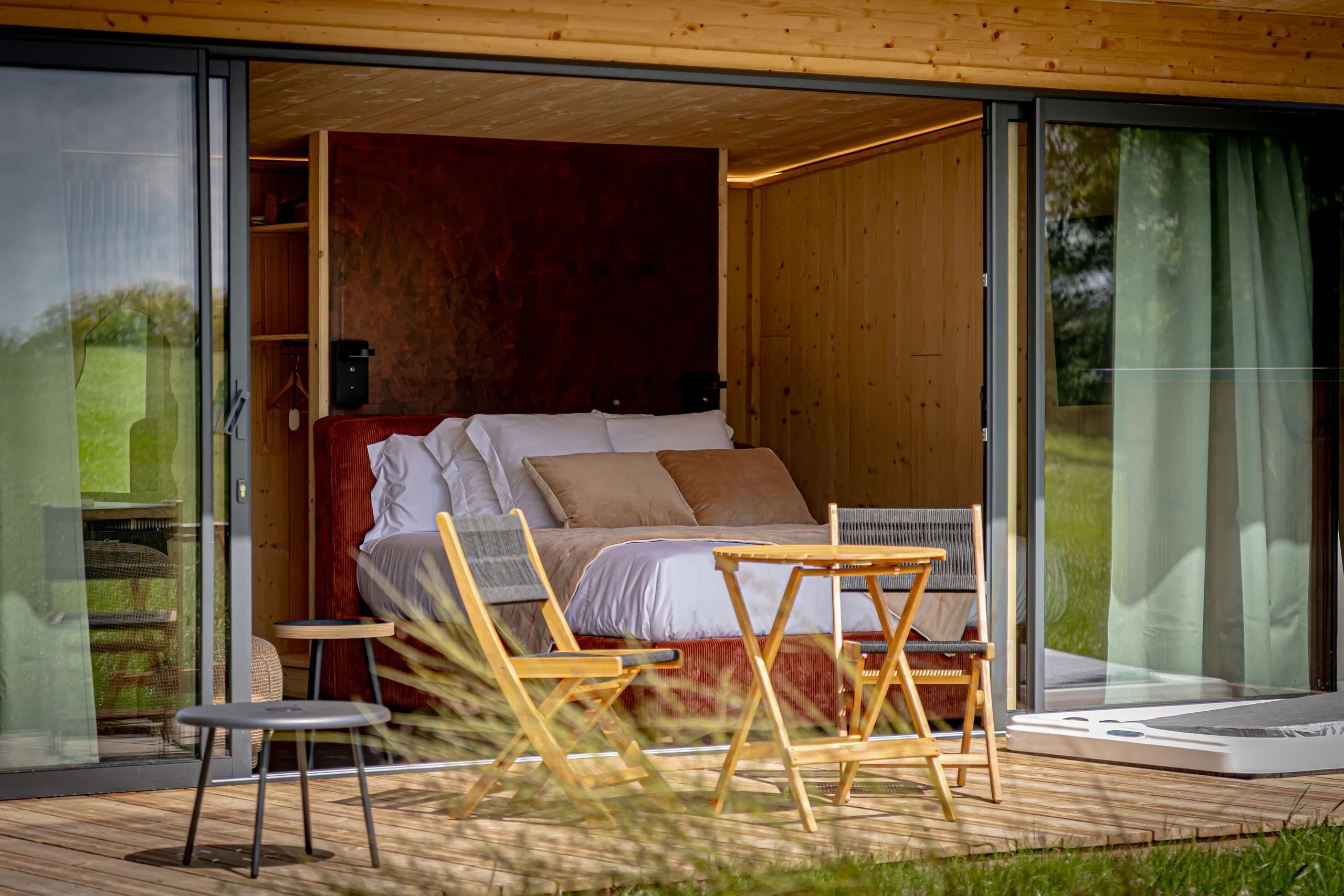 Chambre moderne avec terrasse en bois et mobilier.