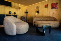 Salon moderne avec meubles en bois et éclairage chaleureux.