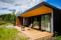 Terrasse en bois avec chaises et paysage verdoyant.