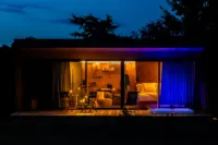 Cabane en bois éclairée la nuit, ambiance cosy.