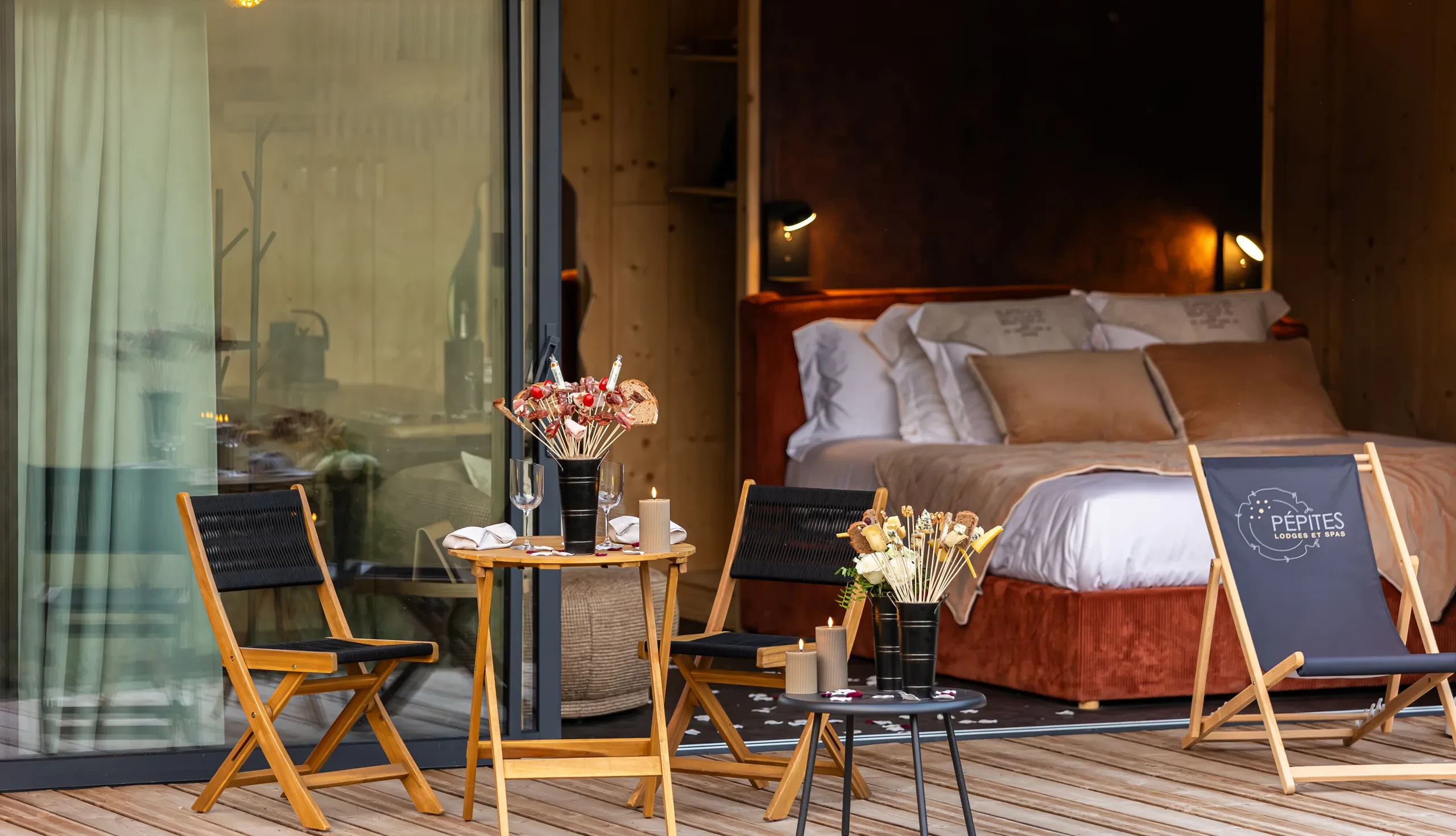 Terrasse cosy avec lit et table garnie.