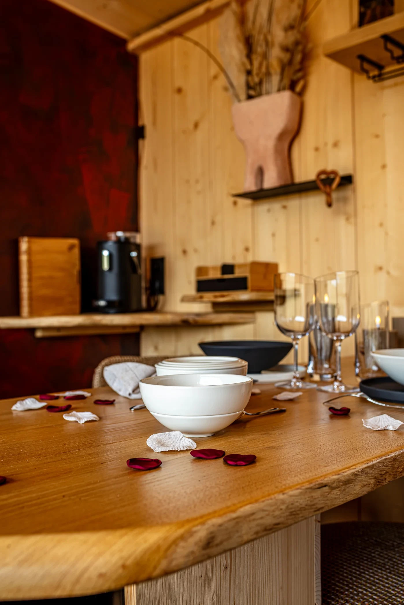 Table en bois dressée avec bougies et pétales