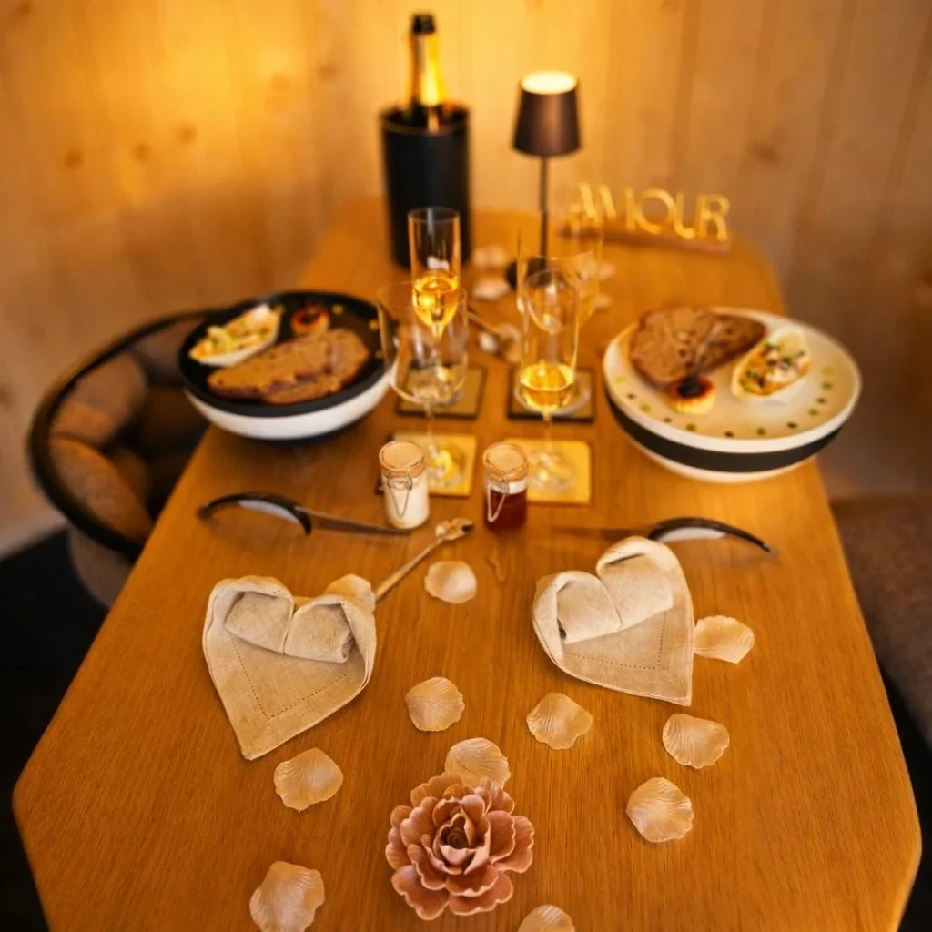Table romantique avec champagne, pétales et cœurs